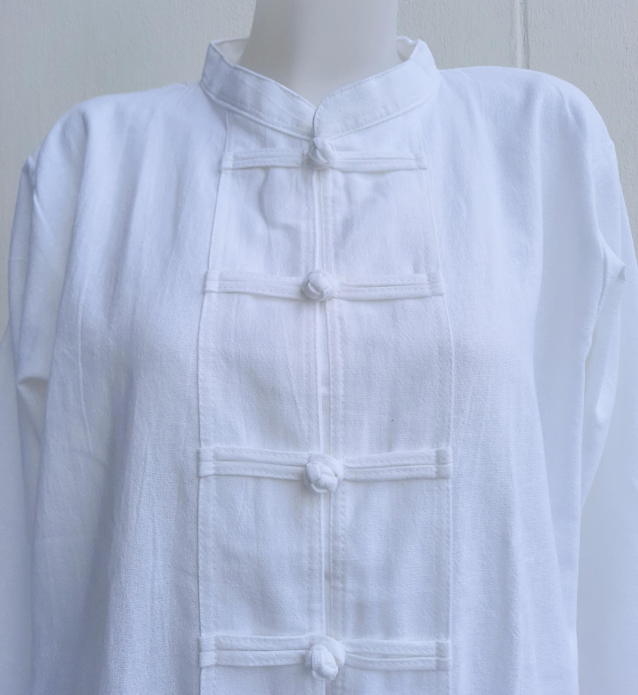 เสื้อคอจีนสีขาว แต่งผ้าปักมือที่กระเป๋า